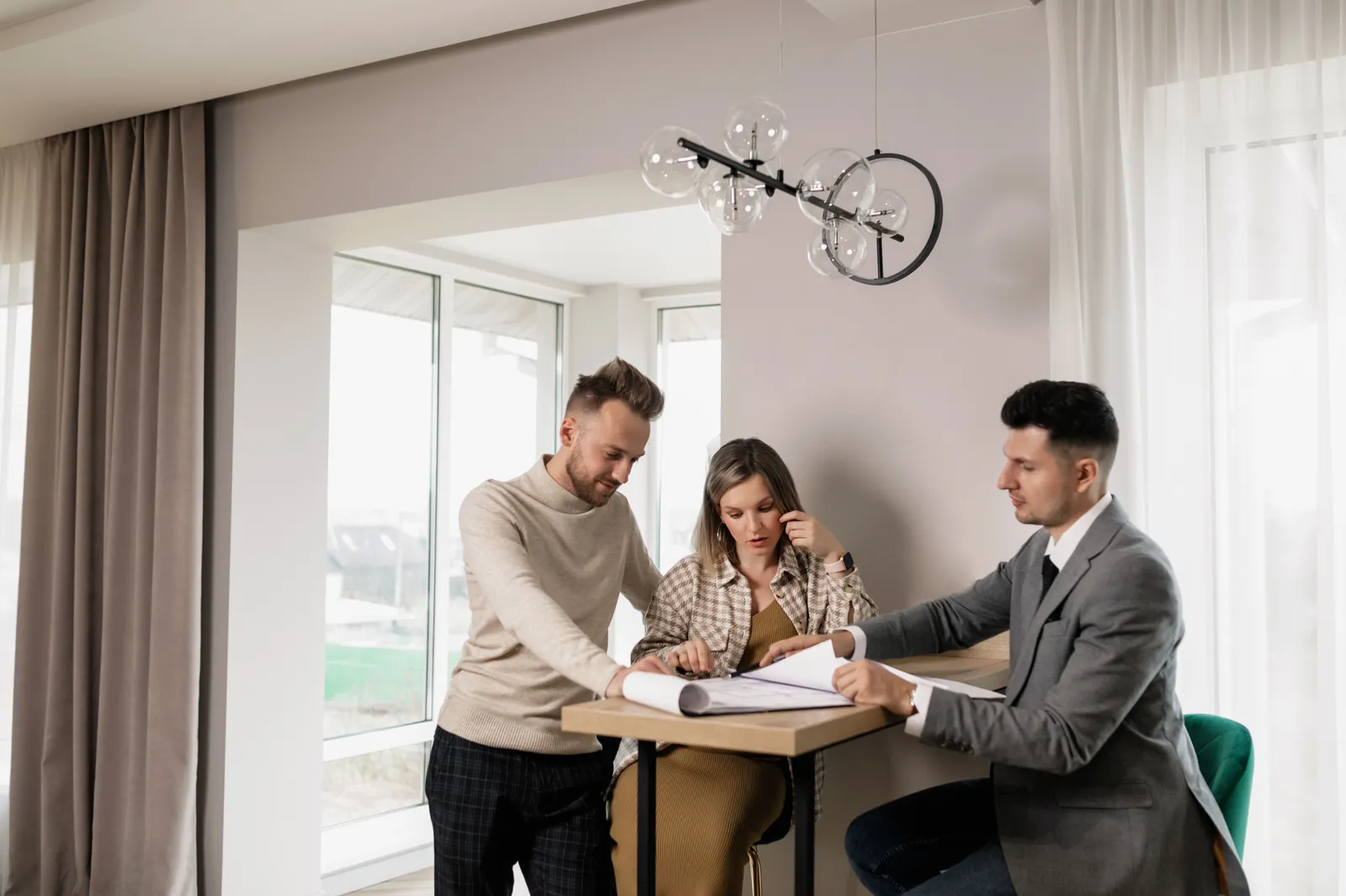 A man showing mortgage papers to a couple seated at a table