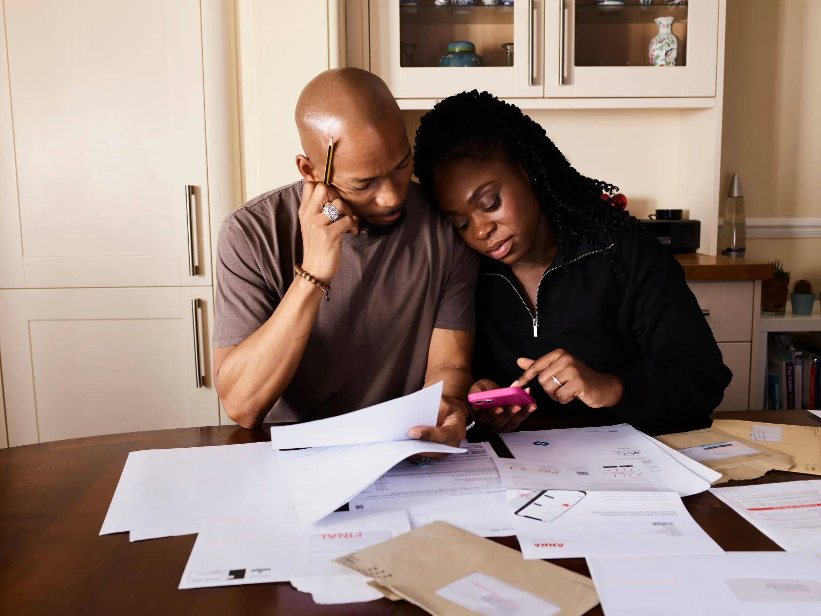 Couple sitting at a table going through household bills and working out expenses