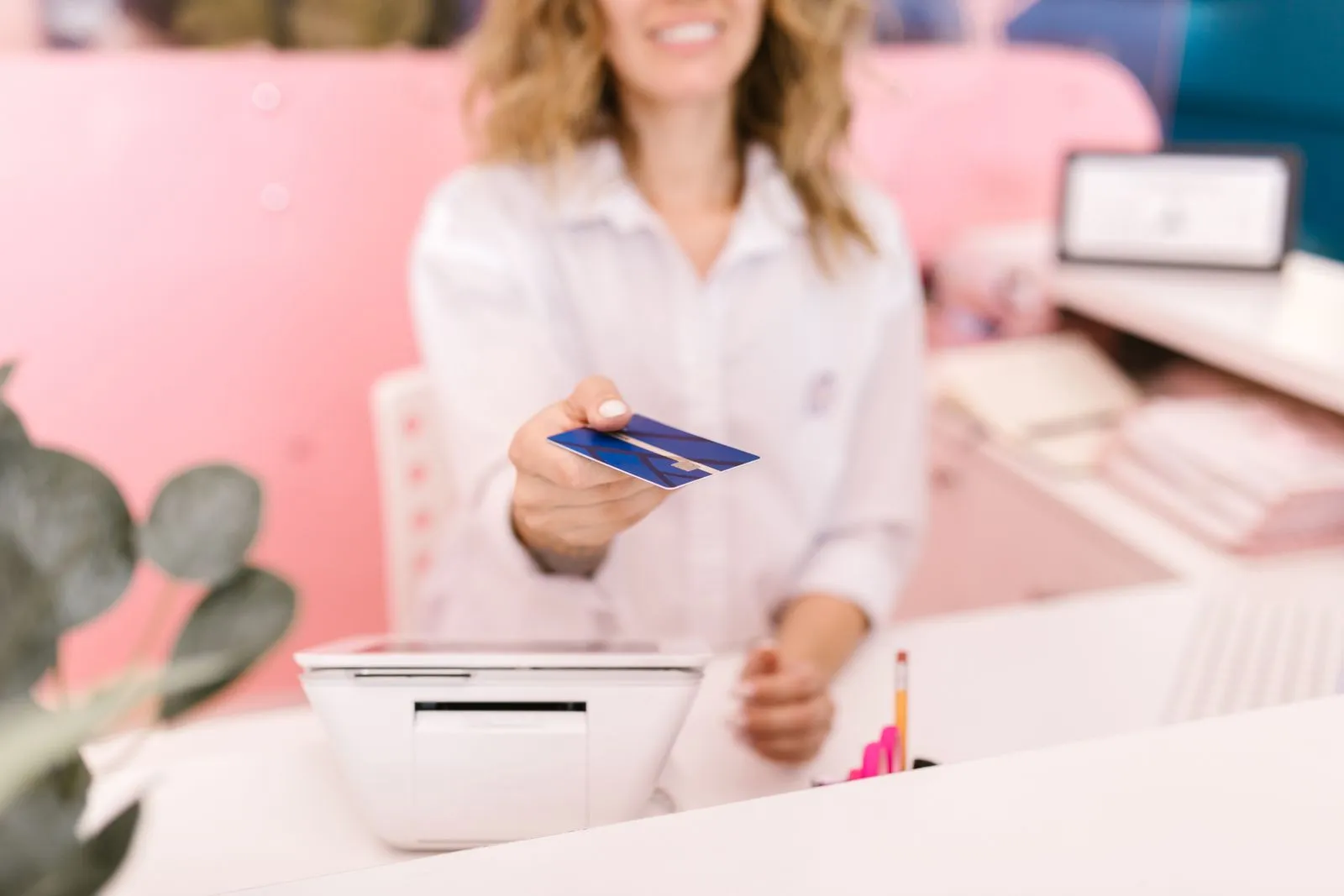 Debit card handed back across a retail counter at checkout