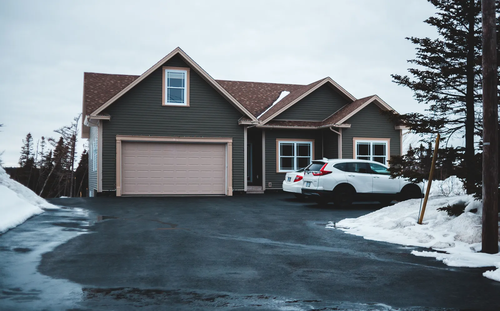 Quiet suburban street with cars parked outside a single family house