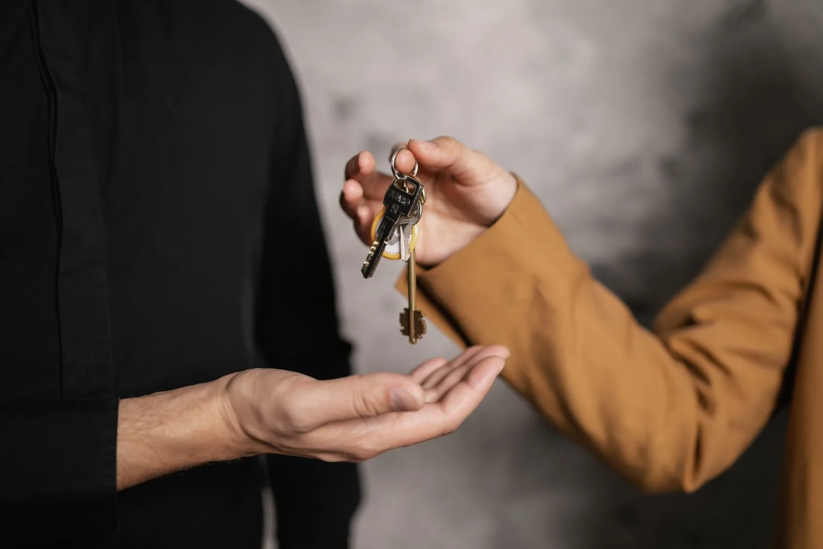 One person handing a set of keys back into someone else's open palm