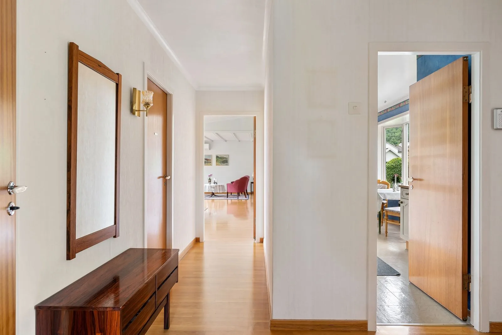 A bright hallway with several open doors leading through to different rooms